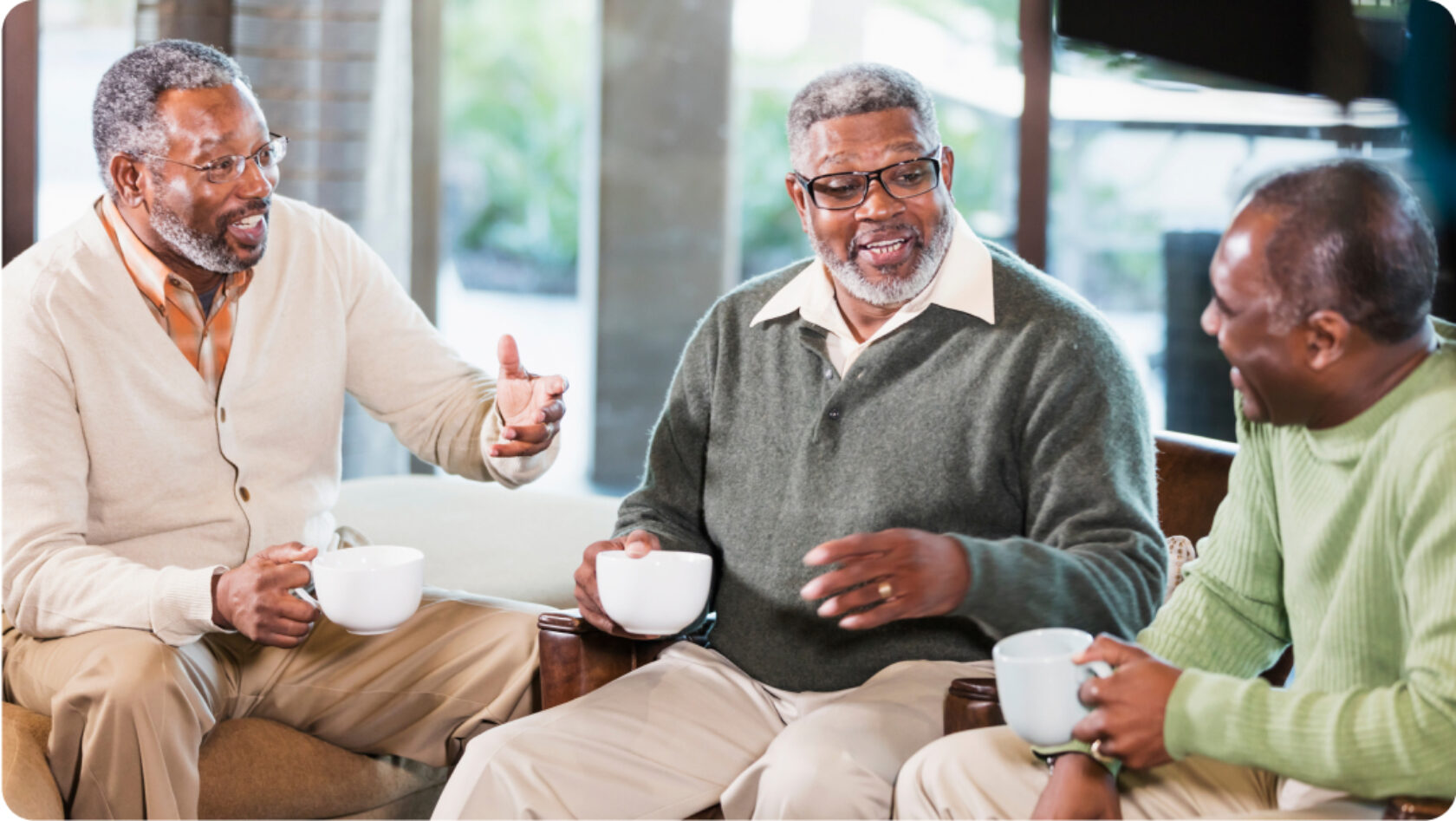 Three friends have a chat over cups of coffee.