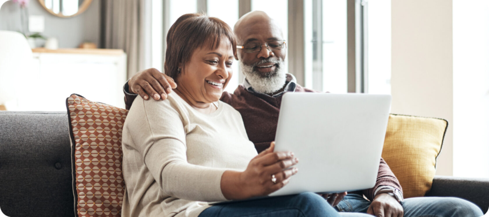 A husband and wife review information on a computer.