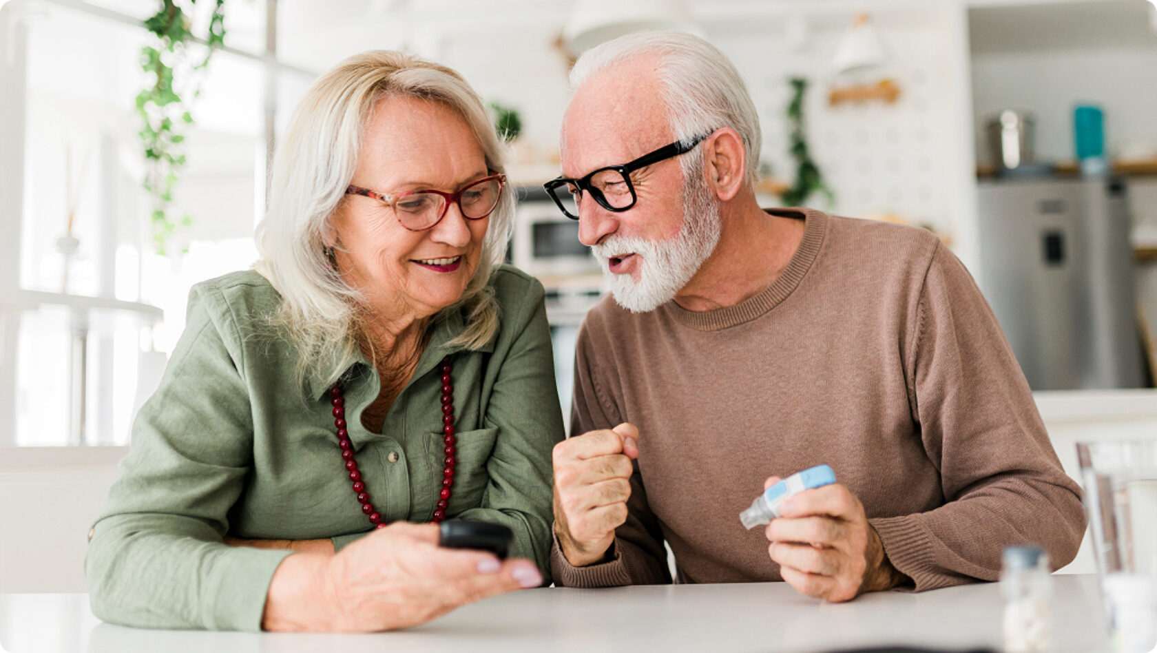 A couple looks at a device with medication on the table.
